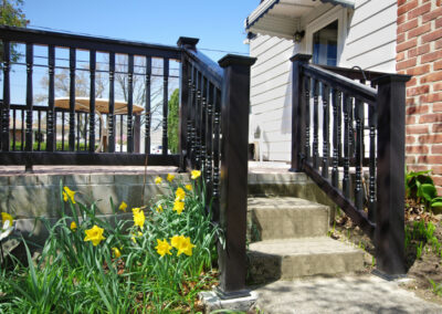 A Grand Illusions vinyl deck railing with a 'T' top and Colonial balusters in black.