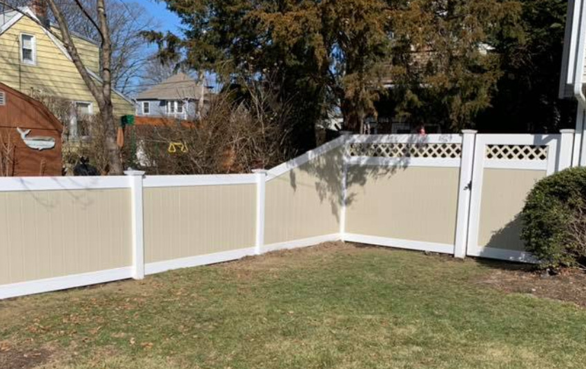 Illusions vinyl fence with Classic White rails and Beige boards with a 6 to 4 transition panel on the left an Illusions fence style V3215D-6 with a matching gate.
