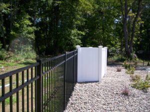 OnGuard aluminum pool fence with Illusions vinyl privacy fence hiding the pool filter and deadning the sound.